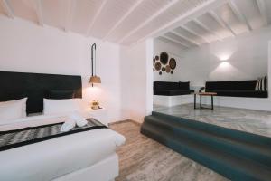 a white bedroom with a large bed and a table at Mr & Mrs White Mykonos in Platis Gialos
