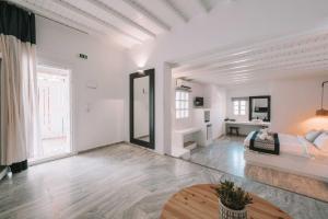 a white living room with a couch and a table at Mr & Mrs White Mykonos in Platis Gialos