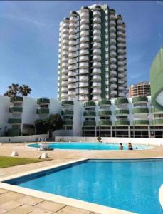 basen hotelowy z wysokim budynkiem w tle w obiekcie Casa Nico OceanView -Apartment 1901 w mieście Portimão