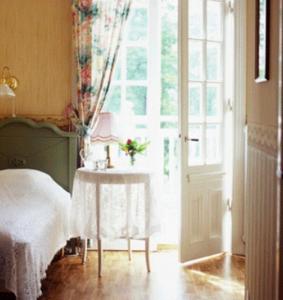 1 dormitorio con cama, mesa y ventana en Solvikens Pensionat, en Ingelstad