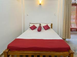 uma cama com almofadas vermelhas num quarto em Coral Cove Beach Resort em Varkala