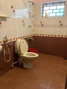 a bathroom with a toilet and a sink at Coral Cove Beach Resort in Varkala