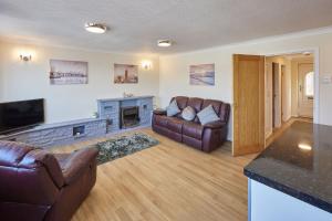uma sala de estar com dois sofás de couro e uma lareira em Host & Stay - Rock Cottage em Whitby