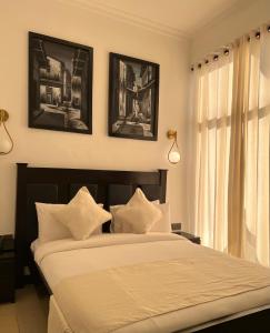 um quarto com uma cama e duas fotografias na parede em Dreams Hotel Zanzibar em Zanzibar