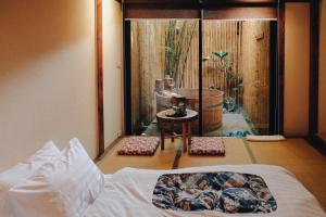 MAYU Bangkok Japanese Style Hotel في بانكوك: غرفة نوم بسرير وإطلالة على حديقة