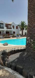 a swimming pool in front of a building at CASA JABLILLO in Costa Teguise