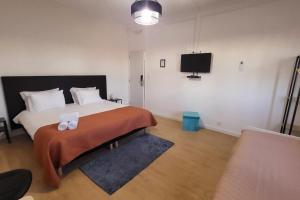 a bedroom with a bed and a tv on the wall at Casa Borges in Charneca