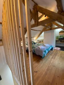 a attic room with a bed and a wooden floor at A La Mémoire de Merlin " Gîte Le Miroir Aux Fées " in Saint-Malon-sur-Mel