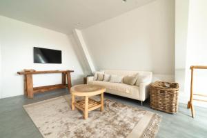 un soggiorno con divano e tavolo di Appartement N05 Bakboord & Stuurboord a Oost-Vlieland