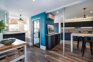 a kitchen with blue walls and a wooden floor at Number One High Street Clare in Sudbury