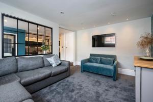 uma sala de estar com um sofá e uma cadeira em Number One High Street Clare em Sudbury