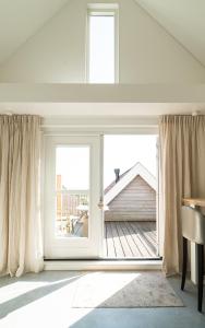 pokój z drzwiami otwartymi na taras w obiekcie Appartement N05 Bakboord & Stuurboord w mieście Oost-Vlieland