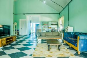 Hello Belle Villa في بانتول: غرفة معيشة مع أريكة وتلفزيون