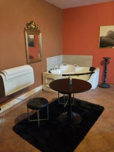 een kamer met een wastafel, een tafel en een bad bij Merope Idrosuite in Serralta