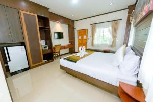 sypialnia z dużym białym łóżkiem i biurkiem w obiekcie BANDER HOTEL w mieście Phu Khieo