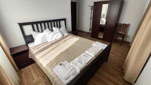 um quarto com uma cama grande e almofadas brancas em Къща за гости - Вила Сидона em Banya