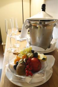 einen Obstteller auf einem Tisch mit Weingläsern in der Unterkunft Weinkastell Zum Weissen Ross in Kallstadt