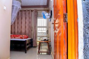 a small room with a bed and a table at Precise Motel in Kampala