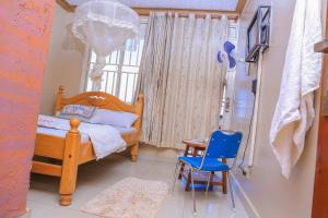 a bedroom with a wooden bed and a blue chair at Precise Motel in Kampala