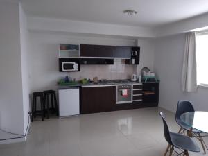 uma cozinha com electrodomésticos a preto e branco e uma mesa e cadeiras em STRADA II em Buenos Aires