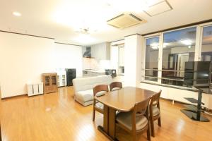 a living room with a table and a couch at STAY IN ASAHIKAWA99 in Asahikawa