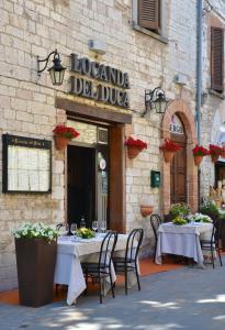 a restaurant with tables and chairs in front of a building at Locanda Del Duca in Gubbio