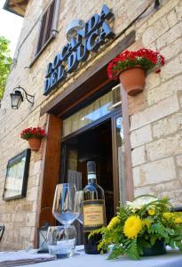 a bottle of wine sitting on a table in front of a restaurant at Locanda Del Duca in Gubbio