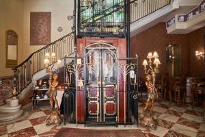 a lobby with a staircase with a large metal gate at Le Metropole Luxury Heritage Hotel Since 1902 by Paradise Inn Group in Alexandria