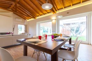 a dining room with a wooden table and chairs at Villa dell'Ulivo - by DomuSicily in Terrasini