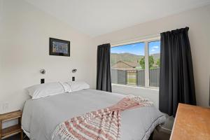 a bedroom with a bed and a large window at Thyme Away - Clyde Holiday Home in Clyde