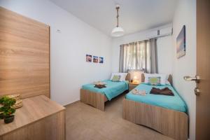 Una habitación con dos camas y una mesa dentro. en Blue View Stegna House, en Archangelos 16 fotos más