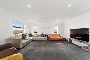 a living room with a couch and a piano at Puna Rise - Taupo Holiday Home in Taupo
