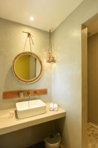 bagno con lavandino e specchio di Veranda Tamarin Hotel & Spa a Tamarin