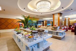una fila di buffet con cibo esposto in un ristorante di Muong Thanh Grand Ha Long Hotel a Ha Long