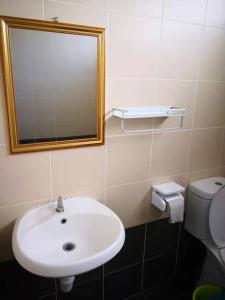 a bathroom with a sink and a mirror and a toilet at FR Comfort SEAView Kuah, Langkawi in Kuah