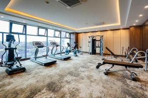 a gym with treadmills and ellipticals in a room with windows at Muong Thanh Grand Ha Long Hotel in Ha Long