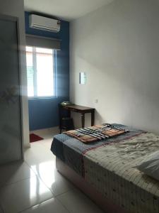 a bedroom with a bed with a desk and a window at FR Comfort SEAView Kuah, Langkawi in Kuah