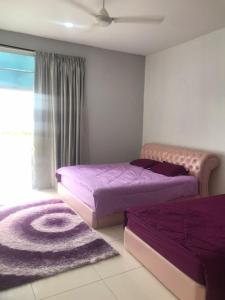 two beds in a bedroom with purple sheets and a rug at FR Comfort SEAView Kuah, Langkawi in Kuah