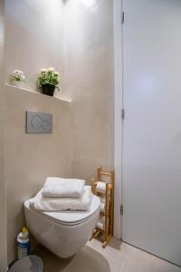 un bagno con servizi igienici e una pianta su una mensola di Deluxe Maisonette With Private Jacuzzi a Molos Parou