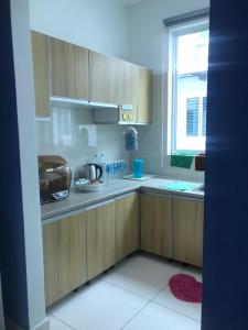 a kitchen with wooden cabinets and a window at FR Comfort SEAView Kuah, Langkawi in Kuah