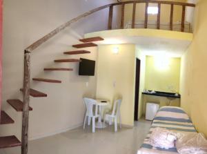 um quarto com uma escada, uma cama e uma mesa em Flats da Paz Maracajaú em Maracajaú