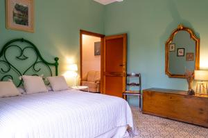 una camera con un grande letto e uno specchio di Villa Poliziana San Benedetto a Montepulciano