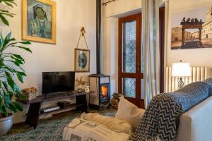 sala de estar con TV y chimenea en Villa Poliziana San Benedetto, en Montepulciano