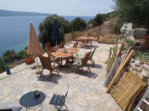 a patio with tables and chairs and the water at Villa with breathtaking views and private beach in Agios Dimitrios