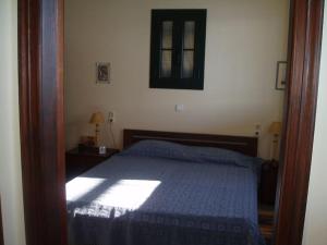 a bedroom with a bed with a blue comforter at Villa with breathtaking views and private beach in Agios Dimitrios +17 photos