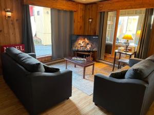 a living room with two couches and a fireplace at Auberge et Chalets sur le Lac in Lac-Mégantic