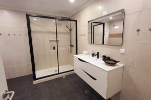 a bathroom with a shower and a sink and a mirror at Casa Borges in Charneca