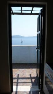 a door to a room with a view of the ocean at Villa with breathtaking views and private beach in Agios Dimitrios