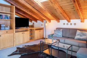 sala de estar con sofá y TV en Sirena Carezza Apartment Masarè en Carezza al Lago