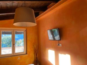 a room with a flat screen tv and a window at Affittacamere L’ Agrumeto in Maratea